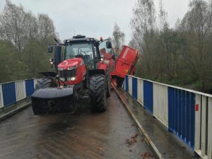 Ciągnik z maszyną rolniczą zawisł na moście! ZDJĘCIA