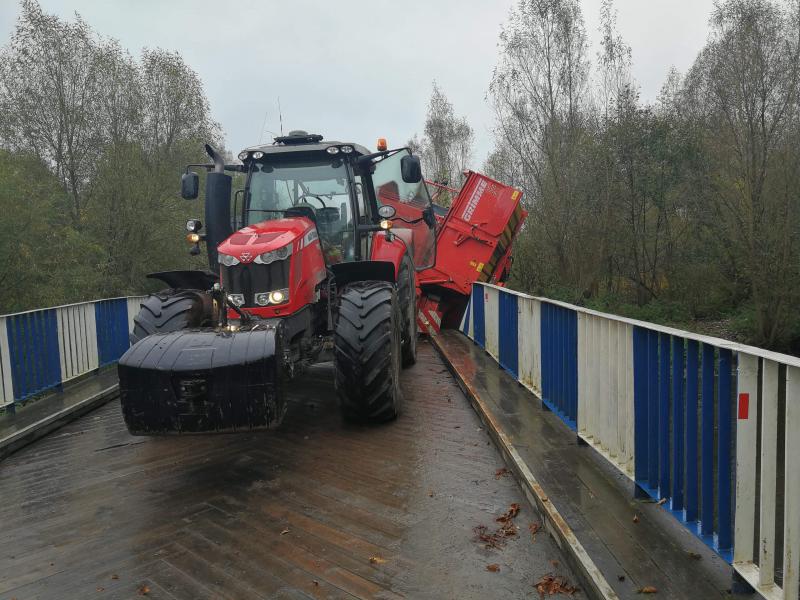 Ciągnik z maszyną rolniczą zawisł na moście! ZDJĘCIA